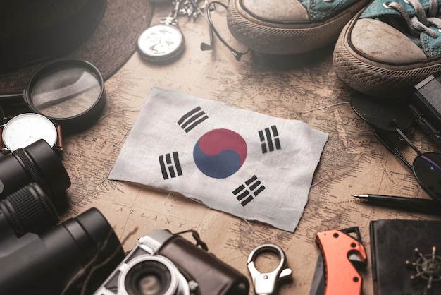 Drapeau de la Corée du Sud entre les accessoires du voyageur sur l'ancienne carte vintage. Concept de destination touristique.