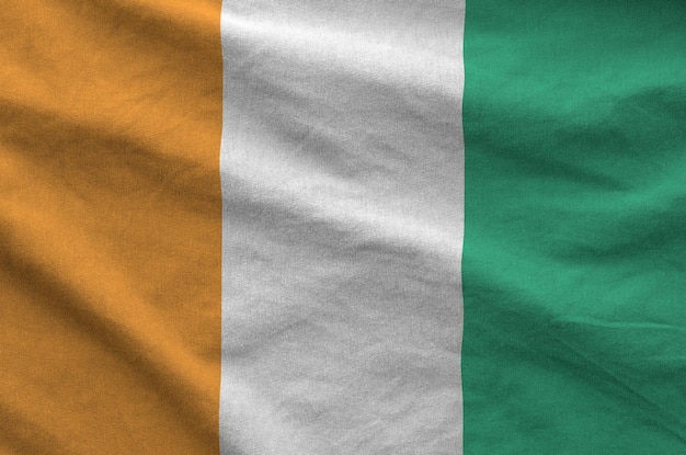 Le drapeau de la Côte d'Ivoire représenté sur un tissu ondulé plié de vieux tissu