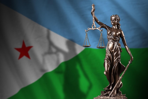 Photo drapeau djiboutien avec statue de dame justice et balance judiciaire dans une pièce sombre concept de jugement et de punition