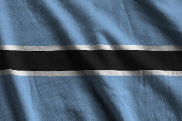 Drapeau du Botswana avec de grands plis agitant de près sous la lumière du studio à l'intérieur Les symboles officiels et les couleurs de la bannière