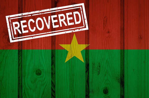 Photo drapeau du burkina faso qui a survécu ou récupéré des infections de l'épidémie de virus corona ou de coronavirus. drapeau grunge avec timbre récupéré