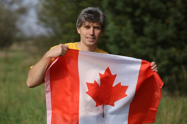 Drapeau du Canada entre les mains d'un homme