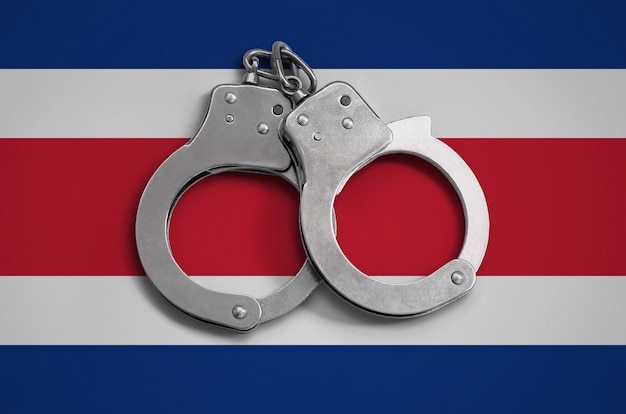 Photo drapeau du costa rica et menottes de police. le concept de respect de la loi dans le pays et de protection contre le crime