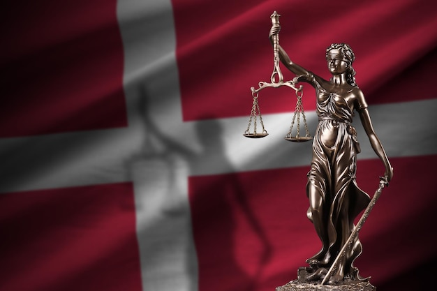 Drapeau du Danemark avec statue de dame justice et balance judiciaire dans une pièce sombre Concept de jugement et de punition