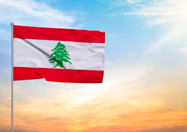 Drapeau du Liban étendu sur un mât de drapeau et en arrière-plan un beau ciel avec un coucher de soleil