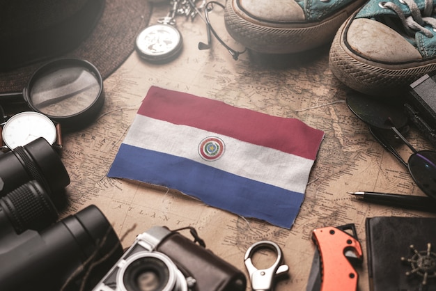 Drapeau du Paraguay entre les accessoires du voyageur sur l'ancienne carte vintage. Concept de destination touristique.