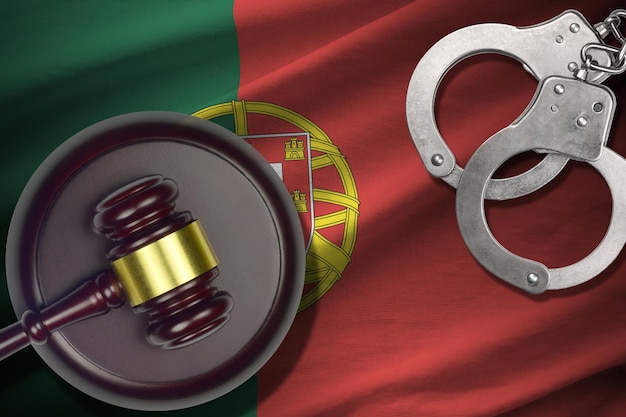 Drapeau du Portugal avec maillet de juge et menottes dans une pièce sombre Concept de fond criminel et punitif pour les sujets de jugement