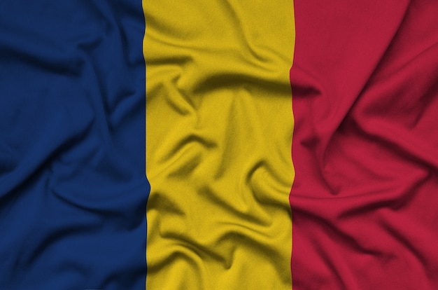 Le drapeau du Tchad est représenté sur un tissu de sport avec de nombreux plis.