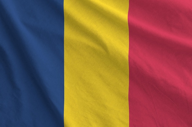 Le drapeau du Tchad représenté sur un tissu ondulé plié d'un vieux tissu