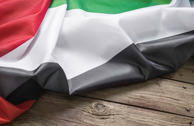 Le drapeau des Emirats Arabes Unis se trouve sur un fond en bois marron avec un espace pour le texte ou l'image