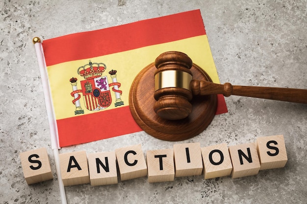 Drapeau espagnol, marteau de juge et cubes en bois avec texte, concept sur le thème des sanctions de l'Espagne