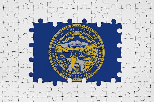 Drapeau d'état américain du Nebraska dans le cadre de pièces de puzzle blanches avec partie centrale manquante