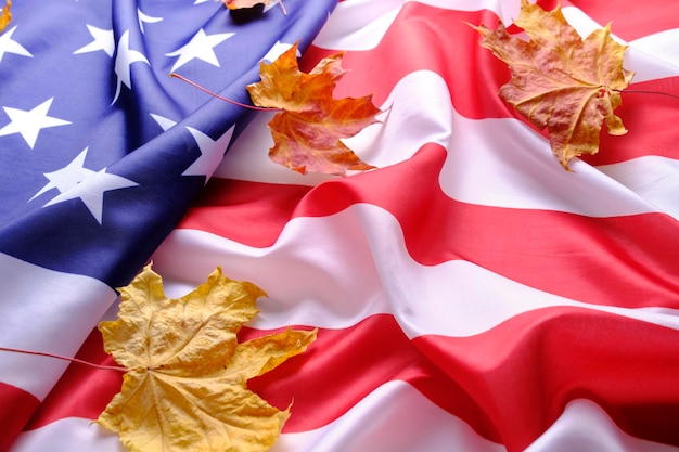 Le drapeau des États-Unis d'Amérique est parsemé de feuilles d'érable d'automne jaunies