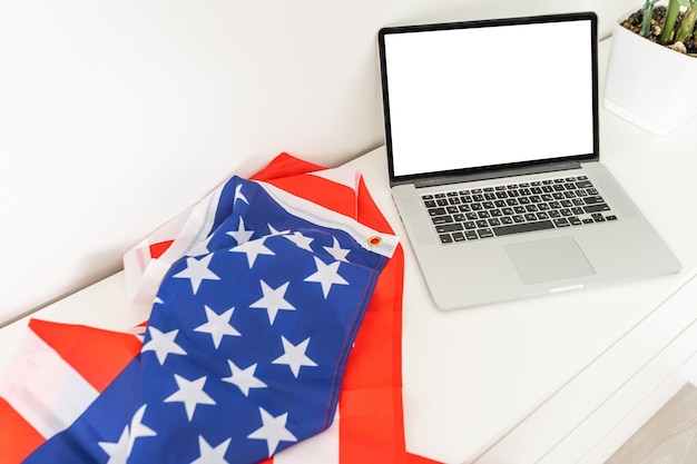 drapeau des états-unis le jour de l'indépendance le 4 juillet , isolé sur fond blanc, derrière un écran d'ordinateur vide vide.