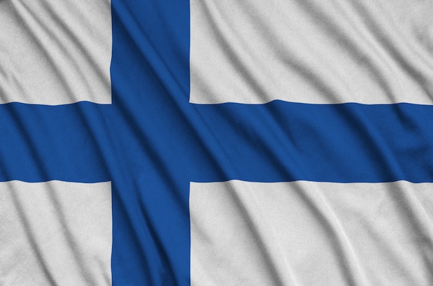 Drapeau de la Finlande est représenté sur un tissu de sport avec de nombreux plis.