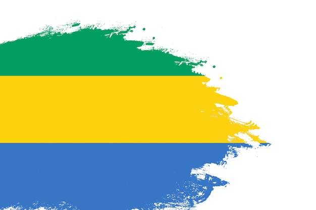 Drapeau gabonais sur un coup de pinceau teinté peint fond blanc isolé avec espace de copie