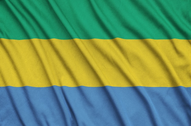 Drapeau gabonais est représenté sur un tissu de sport avec de nombreux plis.