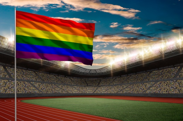 Drapeau gay devant un stade d'athlétisme avec des fans.