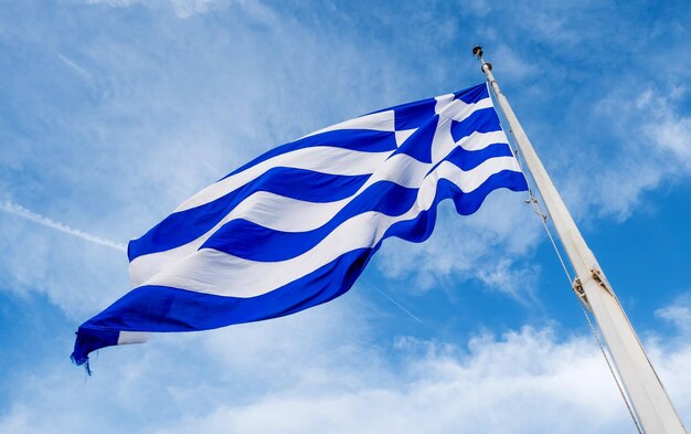 Drapeau grec agitant contre le ciel bleu