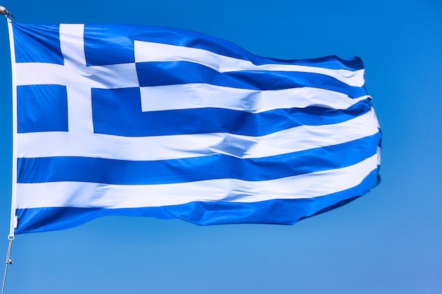 Drapeau de la Grèce en gros plan. Agitant le drapeau grec national contre le ciel bleu