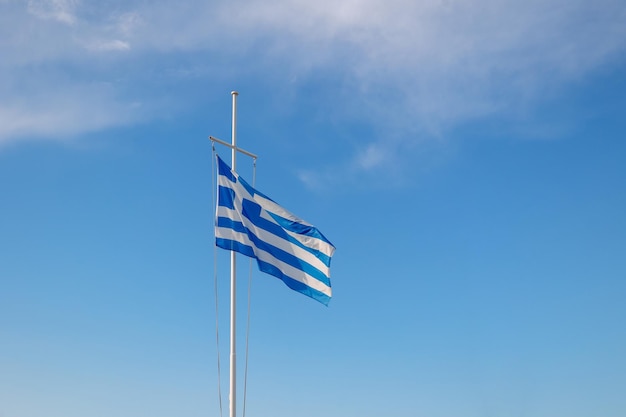 Le drapeau de la Grèce vole dans l'air sur fond de ciel bleu Place de la bannière pour le texte