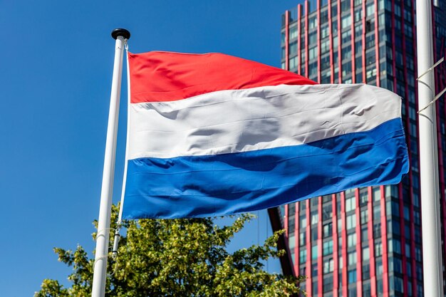 Drapeau hollandais agitant contre un ciel bleu clair