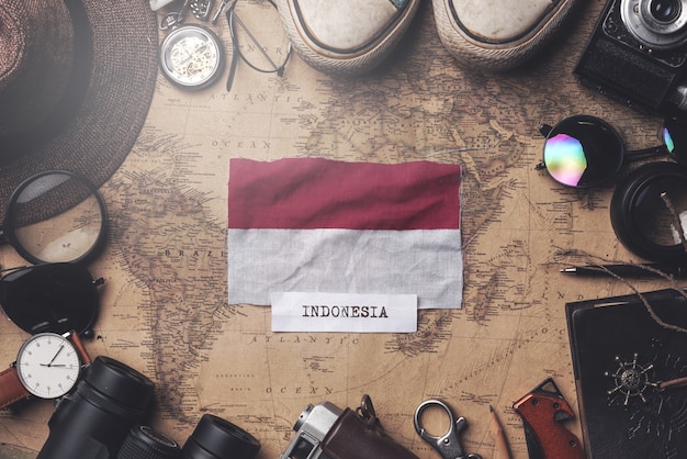 Drapeau de l'Indonésie entre les accessoires du voyageur sur l'ancienne carte vintage. Tir aérien