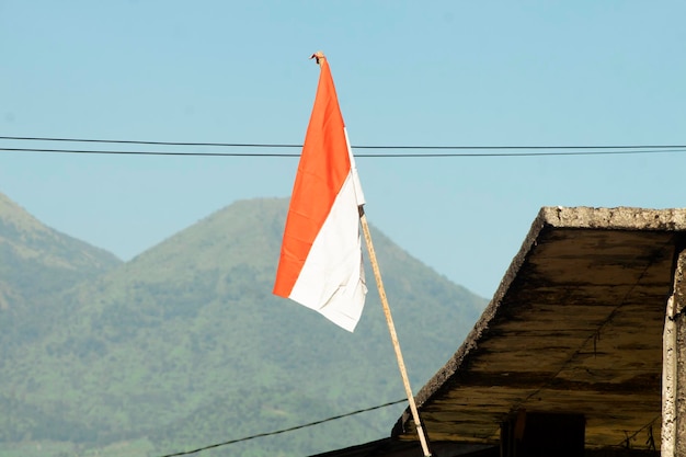 le drapeau indonésien flotte devant la maison pour commémorer le 17 août