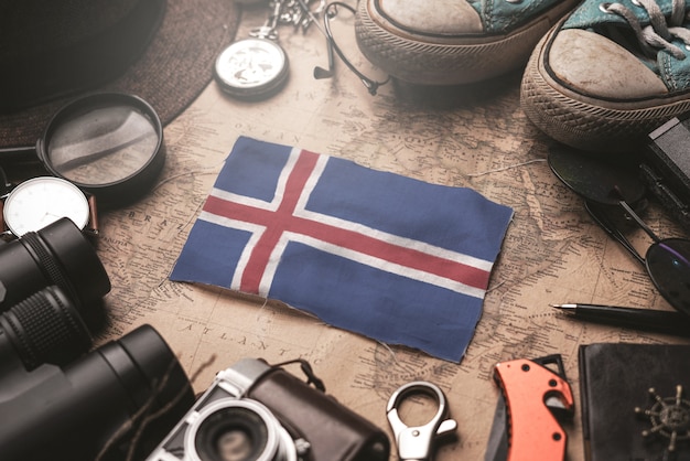 Drapeau de l'Islande entre les accessoires du voyageur sur l'ancienne carte vintage. Concept de destination touristique.