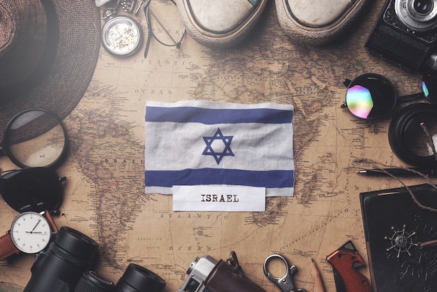 Photo drapeau d'israël entre les accessoires du voyageur sur l'ancienne carte vintage. tir aérien