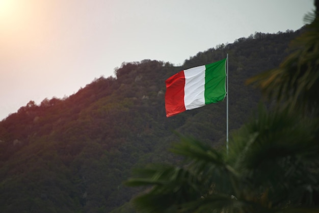 Drapeau de l'Italie dans le ciel avec un fond de montagne drapeau italien