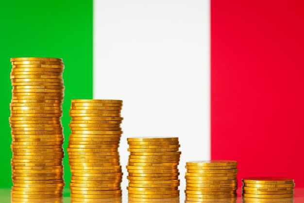 Drapeau de l'Italie avec des piles de pièces d'or formant une progression descendante Crise dans l'économie de l'Italie processus négatif dans les finances du pays