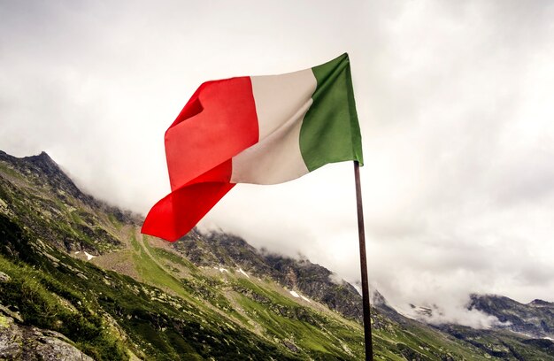 Drapeau italien sur fond des Alpes nuageuses