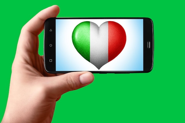 Drapeau italien en forme de coeur sur l'écran Smartphone à la main montre le coeur du drapeau sur le fond hromakey