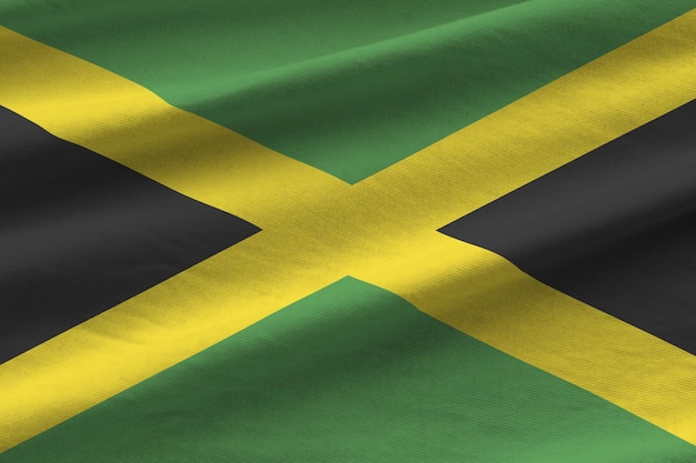 Drapeau jamaïcain avec de grands plis agitant de près sous la lumière du studio à l'intérieur Les symboles officiels et les couleurs de la bannière