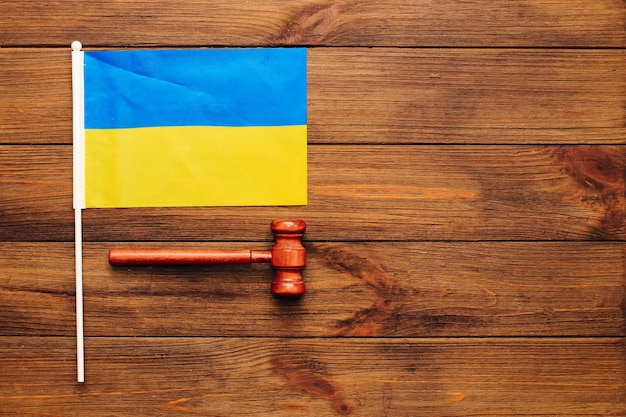 Drapeau jaune bleu ukrainien avec le marteau du juge sur le fond en bois