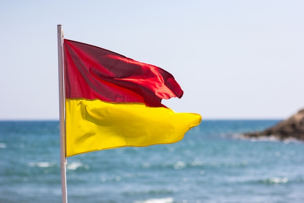 Drapeau jaune rouge sur la côte de la mer. Le concept de sécurité de la vie.