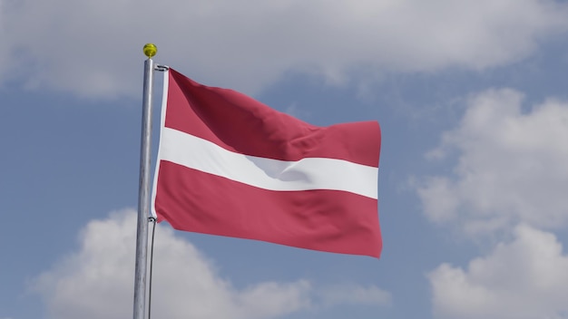 Photo drapeau de la lettonie agitant sur un mât de drapeau ciel de fond avec des nuages