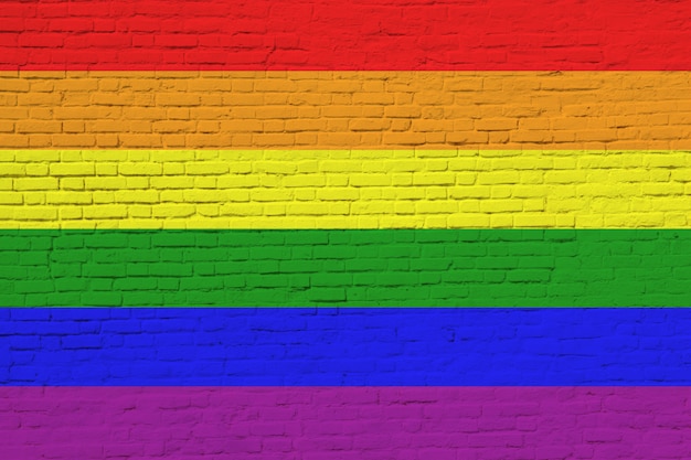 Drapeau LGBT peint sur mur de briques.