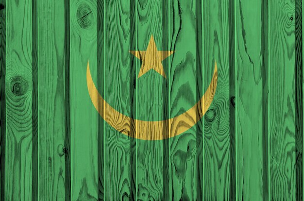 Drapeau de la Mauritanie représenté dans des couleurs vives sur un vieux mur en bois.