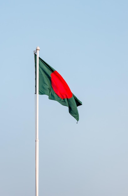 Drapeau national bangladais isolé volant sous le ciel bleu