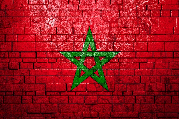 Photo drapeau national du maroc sur fond de mur de brique.