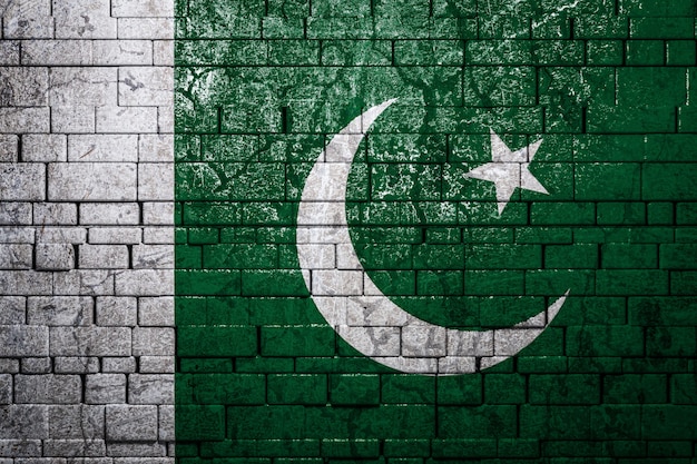 Drapeau national du Pakistan sur fond de mur de brique.