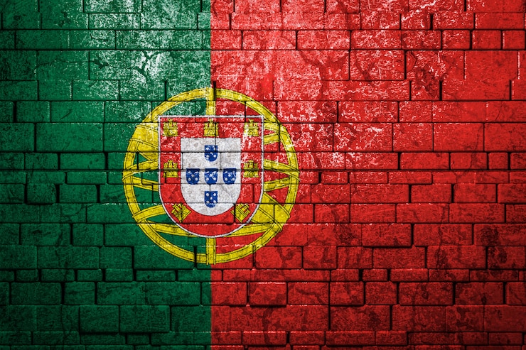 Photo drapeau national du portugal sur fond de mur de brique.