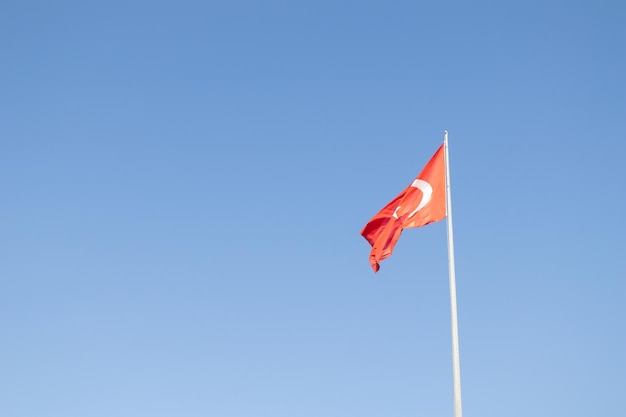 Drapeau national turc sur fond de ciel bleu. Drapeau du pays Turquie