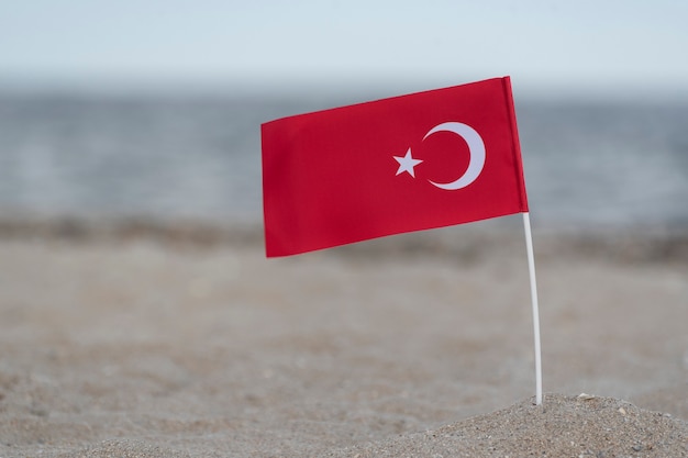 Drapeau national de la Turquie sur le sable de la mer