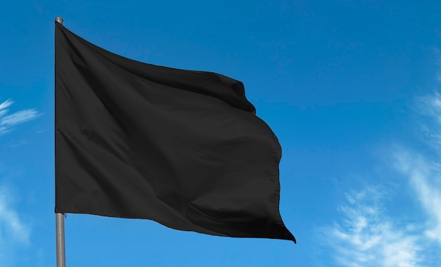 Drapeau noir en tissu blanc contre le ciel bleu