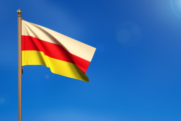 Photo drapeau de l'ossétie du nord soufflé par le vent avec un ciel bleu en arrière-plan