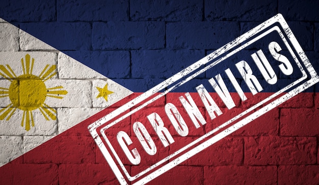 Drapeau des Philippines avec des proportions originales. estampillé du Coronavirus. texture de mur de briques. Notion de virus corona. Au bord d'une pandémie COVID-19 ou 2019-nCoV.