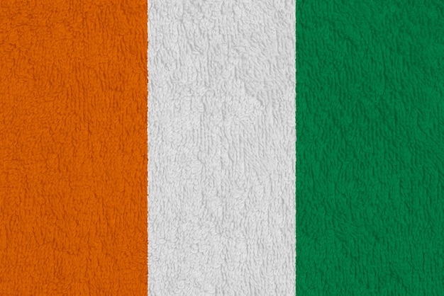 Photo drapeau de la république de côte d'ivoire sur un fond texturé collage conceptuel